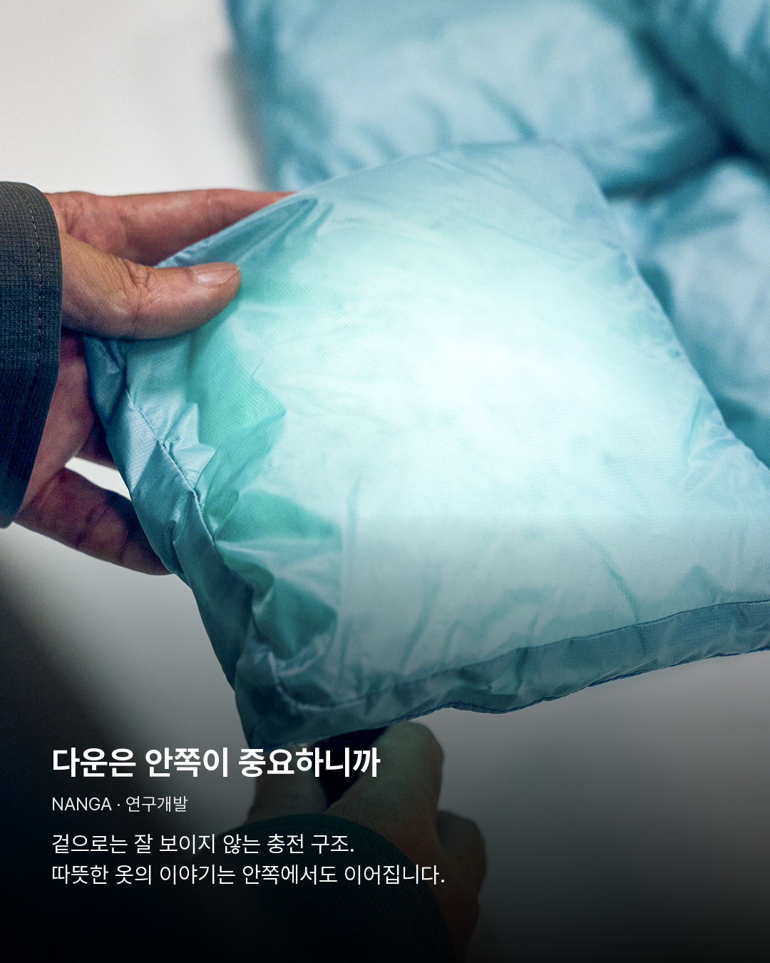 다운 충전 구조를 손으로 살펴보는 연구개발 장면. 다운은 안쪽이 중요하니까。겉으로는 잘 보이지 않는 충전 구조. 따뜻한 옷의 이야기는 안쪽에서도 이어집니다.